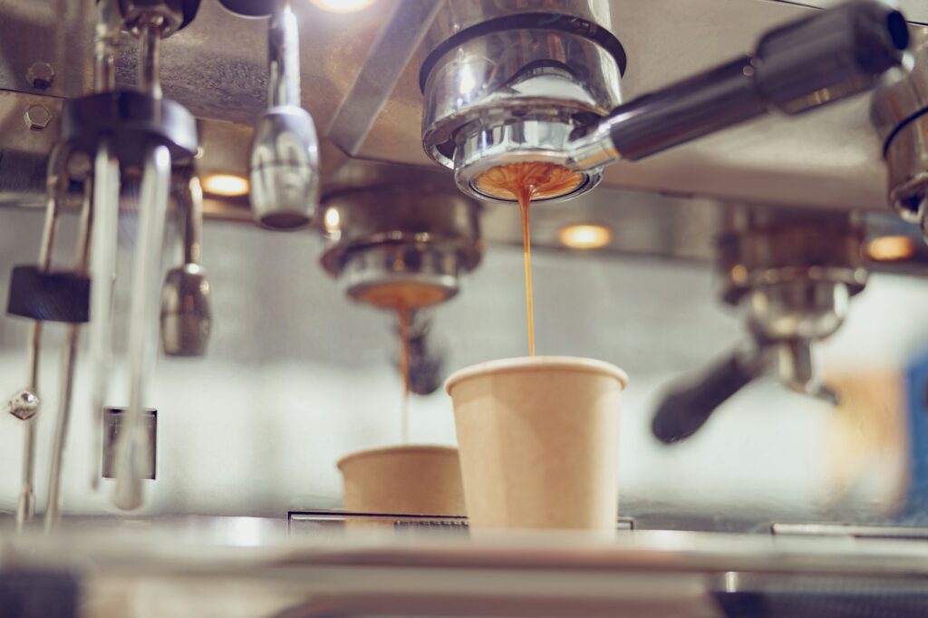 Professional coffee machine with dripping espresso in cafe